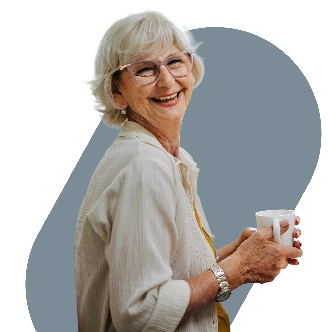 Smiling older woman in glasses holding a white coffee mug against a muted blue background